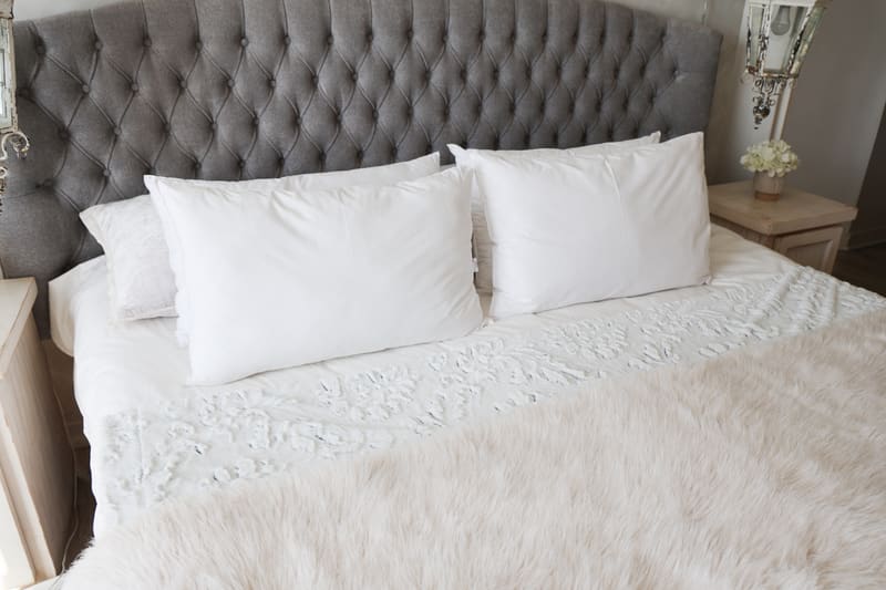 A made bed styled with plump white Dreamland pillows