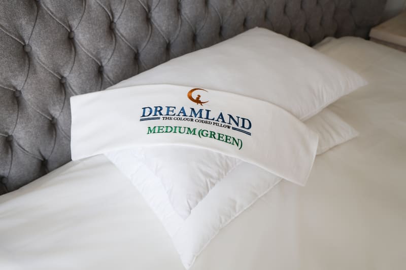 Medium pillow folded to show its green embroidered label