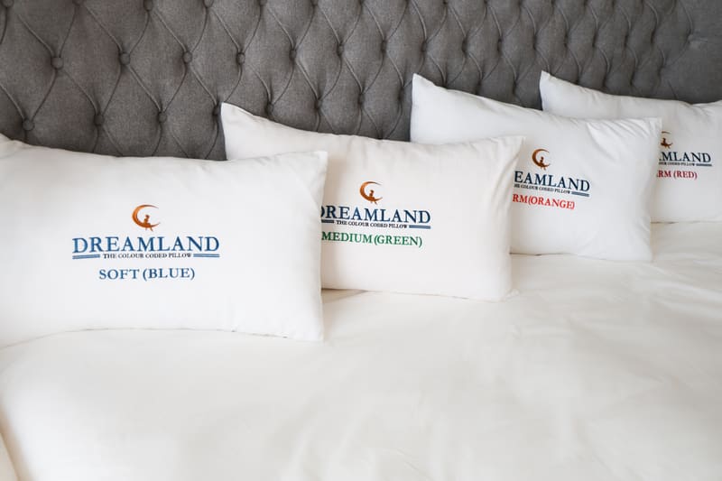 Soft, Medium, Firm and Extra Firm pillows lined up on a white bed